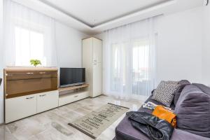 a living room with a couch and a flat screen tv at Luxury apartments Kostrena with pool 2 in Kostrena