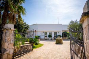 una entrada a un edificio blanco con una puerta en Città Bianca Country Resort en Ostuni