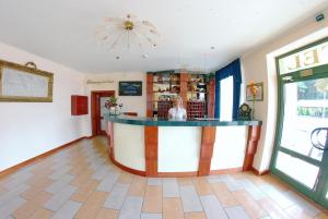 a woman standing at a bar in a room at Hotel Mirage in Sudovaya Vishnya