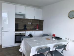 uma cozinha com mesa e cadeiras num quarto em Appartement Futuroscope-P' em Chasseneuil-du-Poitou