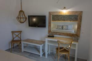 a room with a bed and a desk and a tv at Rafael Hotel-Adults Only in Lindos