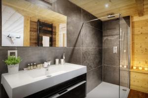 a bathroom with a white sink and a shower at Chalet Victorina - OVO Network in La Giettaz