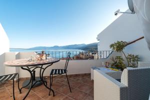 balcón con mesa, sillas y vistas en Sebastian House en Cala Gonone