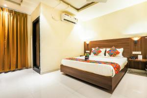 a bedroom with a large bed in a room at FabHotel RR Grand MG Road in Vijayawāda