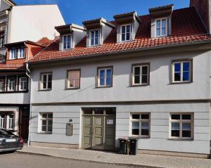 une maison blanche avec un toit rouge dans l'établissement Zum Augustiner I, Erfurt Zentrum, à Erfurt