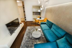 sala de estar con sofá azul y mesa en Apartment Lana en Banja Luka