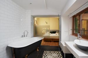 uma casa de banho com uma banheira, um lavatório e uma banheira. em Hostel Sóller em Sóller