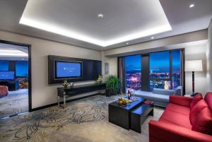 
a living room filled with furniture and a tv at Pullman Guiyang in Guiyang
