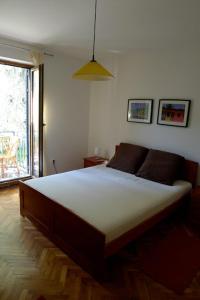 1 dormitorio con 1 cama grande en una habitación con ventana en Apartments Maslina, en Sveti Stefan