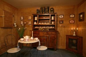 a room with a table and chairs and a shelf at Hotel Letterario Locanda Collomb in La Thuile