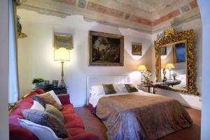 a bedroom with a bed and a couch and a mirror at Terrazza De Medici in Florence