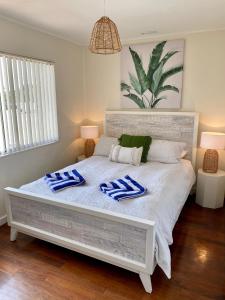 Una cama blanca con almohadas azules y blancas. en Central Views, en Jurien Bay