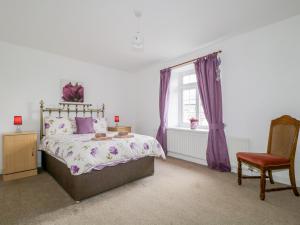une chambre avec un lit, une chaise et une fenêtre dans l'établissement Fountain Cottage, à Keswick