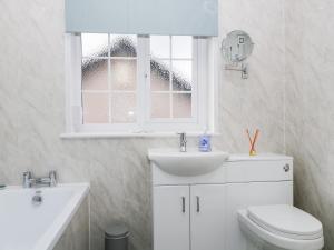 une salle de bain avec toilettes, lavabo et fenêtre dans l'établissement Fountain Cottage, à Keswick 10 autres photos
