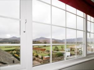 une fenêtre avec vue sur une campagne vue à travers elle dans l'établissement Fountain Cottage, à Keswick