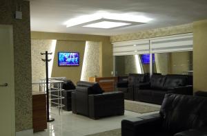 a living room with black leather furniture and a tv at Gevher Hotel in Kayseri