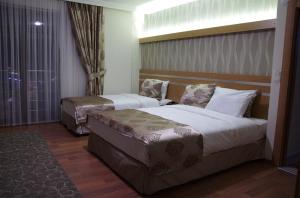 a hotel room with two beds and a window at Gevher Hotel in Kayseri