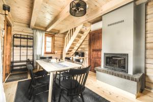 - une salle à manger avec une cheminée dans une cabane en rondins dans l'établissement Kalnziedi, à Sigulda