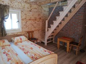 a bedroom with a bed and a stair case at Seoski turizam Ziličina Rogatica in Rogatica