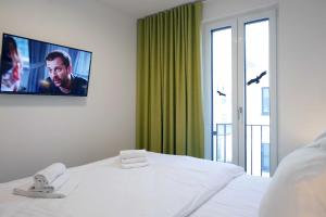 a bedroom with a bed with a tv on the wall at Baabe Villen Ensemble FeWo 32 Meer in Baabe