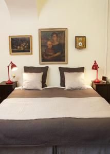 a bedroom with a large bed with two pictures on the wall at Lady Hamilton Apartments in Stockholm