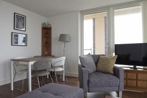 a living room with a table and a chair and a television at Toothbrush Apartments - Ipswich Waterfront South - Avalon Court in Ipswich