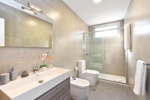 a bathroom with a sink and a toilet and a mirror at Top Salobre Villas by VillaGranCanaria in Salobre