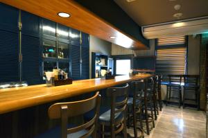 a bar with a row of bar stools in a restaurant at Isahaya Daiichi Hotel in Isahaya