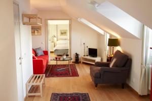 a living room with a red couch and a bed at Lady Hamilton Apartments in Stockholm