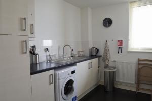 a kitchen with a sink and a washing machine at Toothbrush Apartments - Ipswich Waterfront South - Avalon Court in Ipswich