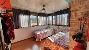 una camera con due letti, un divano e finestre di Airport BCN, Atico terraza & BBQ, Puerto Cruceros a 15 minutos a Viladecáns