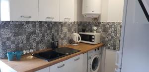 a kitchen with a sink and a microwave at Północna Rooms in Łódź