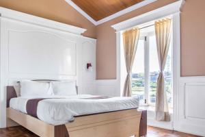 a bedroom with a bed and a large window at Pine View Stay Ooty in Ooty