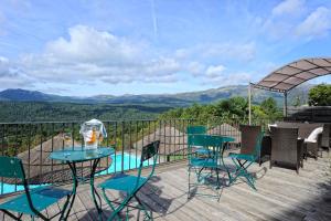 una terraza con mesa, sillas y piscina en Appartement du Tourisme en Zonza