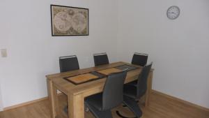 mesa de comedor con sillas y reloj en la pared en KEHL Center Schöne 2 Zimmer Wohnung mit Terrasse 60M2 en Kehl am Rhein