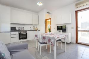 a kitchen with a table and chairs and a kitchen with white cabinets at Villino Gramsci in San Teodoro