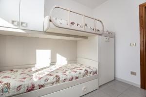 a white bedroom with a bunk bed with aroll at Villino Gramsci in San Teodoro +8 photos
