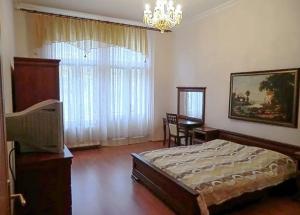 1 dormitorio con 1 cama, TV y ventana en 7k - Apartmány Lázeňská, en Karlovy Vary