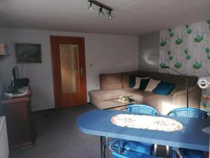 a living room with a couch and a blue table at Ferienwohnung Fröhlich in Bad Suderode