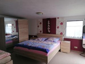 um quarto com uma cama grande e 2 janelas em Ferienwohnung Fröhlich em Bad Suderode