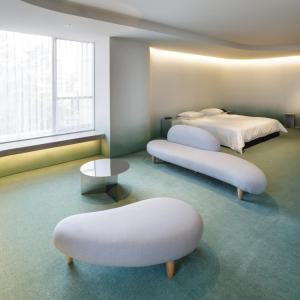 um quarto com duas camas com repousa-pés e uma mesa em The Screen em Quioto