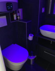 a purple bathroom with a toilet and a sink at BAGATELLE NATURISTE HELIOPOLIS clim ascenseur vue mer parking privé in Cap d'Agde