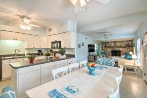 a kitchen with white cabinets and a table and chairs at Home with Dock, Pool, Kayaks Walk to Palma Sola Bay in Bradenton