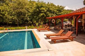 una piscina con bancos y un cenador en Makri Otel, en Muğla