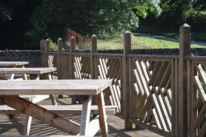 um grupo de mesas de piquenique e uma cerca de madeira em The Black Dog Inn em Dalton in Furness