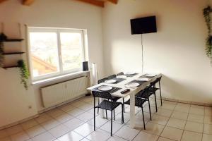 a dining room with a table with chairs and a window at Workers Apartment- three room apartment with kitchen and wifi in Büsingen