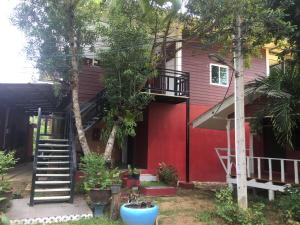 a red house with a staircase in front of it at Ducklingresort And Bar in Trat