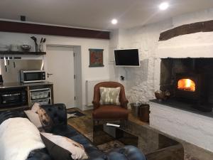 sala de estar con sofá y chimenea en Beautifully Renovated Self-Contained Farm Cottage - close to beaches, North Berwick and the Golf Coast, en North Berwick