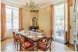 a dining room with a table with chairs and a chandelier at Résidence Regina in Cauterets