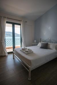 a bedroom with a bed with a view of the ocean at Velanidia Apartments in Plataria